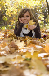 Austria, Female teenager (14-15), relaxing on leaves, portrait - WWF00850