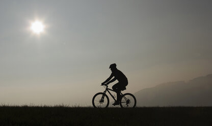 Mann auf einem Mountainbike, Dämmerung, Silhouette - WWF00844
