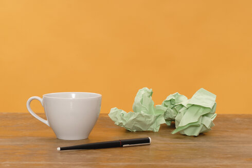 Cup of coffee, pen, paper balls, close up - KJF00037