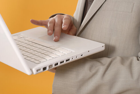 Businessman using laptop, middle section, close up - KJF00026