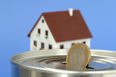 Money box with Euro coin, house in background - ASF03862