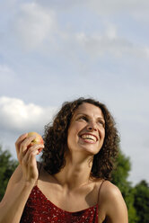Young woman holding apple, smiling, portrait - KJF00060