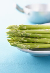 Green asparagus on platter, in background cooking pot - KSWF00394