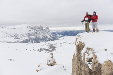 Italien, Südtirol, Pärchen mit Schneeschuhen auf Berggipfel stehend - WESTF11340