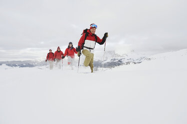 Italy, South Tyrol, Four people in a row, snowshoeing - WESTF11334