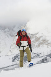 Italy, South Tyrol, Man snowshoeing, smiling - WESTF11331