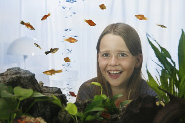 Girl (8-9) watching fish, view through fish tank - RBF00027
