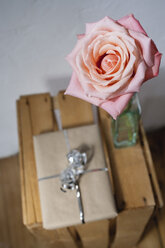 Gift parcel and rose on wooden box, elevated view - JRF00105