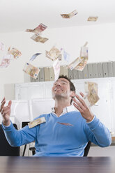 Germany, Munich, business man in office throwing banknotes - LDF00638