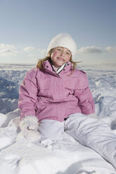 Germany, Bavaria, Munich, Girl (6-7) sitting in snow, smiling, portrait - RBF00075