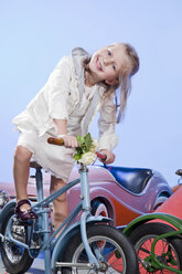 Germany, Landshut , little girl (4-5) riding carousel bike, smiling - MAEF01639