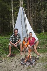 Österreich, Salzburger Land, Familie sitzt am Lagerfeuer - HHF02915