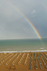 Italien, Lignano Strand mit Liegestühlen, Regenbogen im Hintergrund - HHF02894