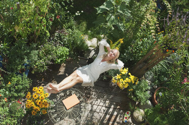 Austria, Salzburger Land, Young woman in garden, relaxing, elevated view - HHF02860