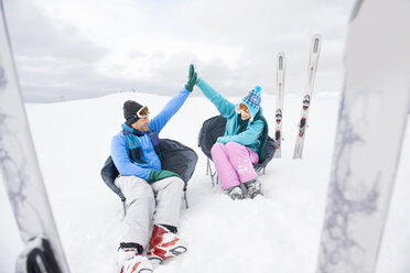 Italy, South Tyrol, Seiseralm, Couple relaxing in snow - WEST11660