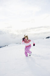 Italy, South Tyrol, Seiseralm, Woman running in snow field - WEST11653