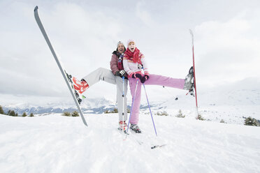 Italien, Südtirol, Seiseralm, Pärchen auf Skiern stehend, Bein anheben - WEST11631