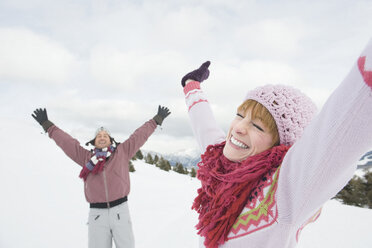 Italien, Südtirol, Seiseralm, Pärchen im Schneefeld, Arme ausgestreckt - WEST11613