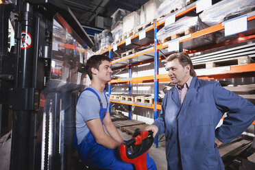 Germany, Neukirch, Apprentice and foreman in storeroom - WESTF11913