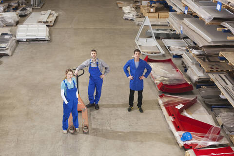 Deutschland, Neukirch, Ausbilder und Lehrlinge stehen in einer Industriehalle, Ansicht von oben, lizenzfreies Stockfoto