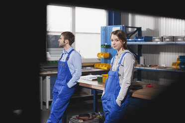 Germany, Neukirch, Young woman and foreman at workstation, having a break - WESTF11882