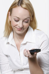 Young woman using mobile phone, portrait - KSWF00529