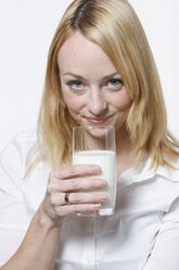 Junge Frau trinkt ein Glas Milch, Porträt - KSWF00518