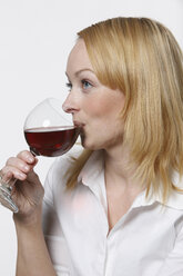 Junge Frau trinkt Rotwein, Porträt - KSWF00515
