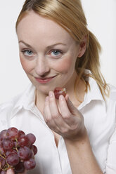 Junge Frau mit Weintrauben, lächelnd, Porträt - KSWF00504