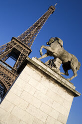 France, Paris, Eiffel Tower, Pont d'Lena, Statue in foreground, low angle view - PSF00155