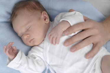 Deutschland, Bayern, München, Baby (3 Wochen) schlafend, von Erwachsenenhand berührt, Nahaufnahme - CRF01684