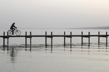 Deutschland, Bayern, Starnberger See, Frau fährt mit dem Fahrrad über die Uferpromenade - CRF01668