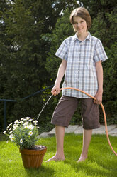 Germany, Baden-Württemberg, Stuttgart, Boy (12-13) watering plant - WDF00512