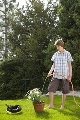 Germany, Baden-Württemberg, Stuttgart, Boy (12-13) watering plant - WDF00511