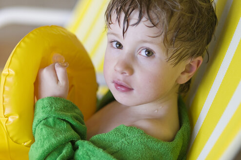 Germany, Baden-Württemberg, Boy (4-5) sitting on chair in indoor swimming pool, portrait - SMF00458