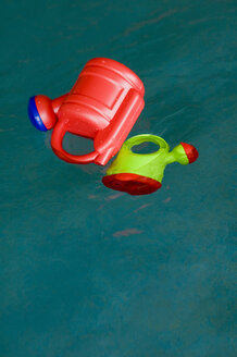 Germany, Baden-Württemberg, Plastic watering can floating in pool - SMF00455