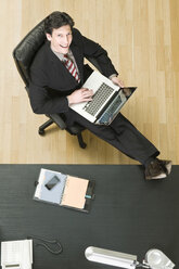 Germany, Munich, Businessman working at laptop, elevated view - WESTF11809