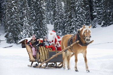 Italien, Südtirol, Seiseralm, Weihnachtsmann und Kinder bei einer Schlittenfahrt - WESTF11466