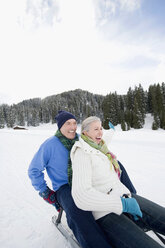 Italien, Südtirol, Seiseralm, Seniorenpaar beim Schlittenfahren, lachend, Portrait - WESTF11449