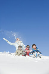 Italien, Südtirol, Seiseralm, Familie sitzt im Schnee, lachend - WESTF11414