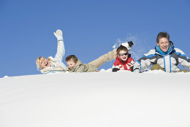 Italien, Südtirol, Seiseralm, Familie im Schnee liegend, lachend, Portrait - WESTF11412