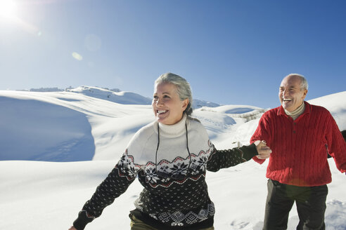 Italy, South Tyrol, Seiseralm, Senior couple in winter scenery - WESTF11384