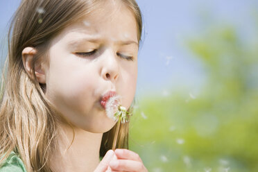 Germany, Bavaria, Munich, Girl (6-7) blowing dandelion seeds, eyes closed, portrait - CLF00731