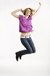 Junge Frau springt in die Luft, lächelnd, Porträt - CLF00772
