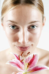 Young woman with orchid flower, portrait, close-up - WESTF11947