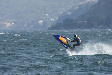 Italy, Lake Como, Man riding speedboat - FFF01074