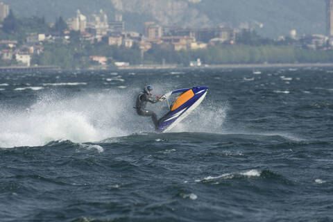 Italy, Lake Como, Man riding speedboat stock photo