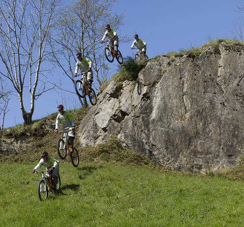 Italien, Comer See, Mountainbiker fahren über Felsen, lizenzfreies Stockfoto