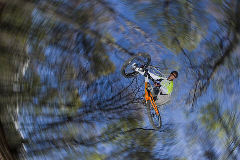 Italien, Comer See, Mountainbiker beim Sprung, Tiefblick, lizenzfreies Stockfoto