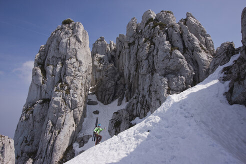 Germany, Bavaria, Chiemgau, Kampenwand, Man with skis walking uphill - FFF01067